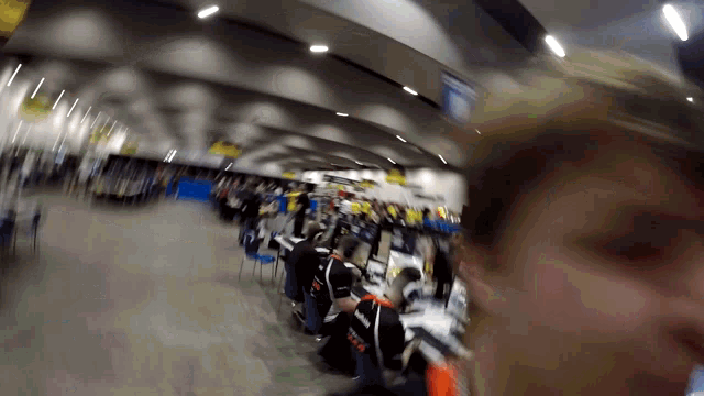 a blurry picture of people in a room with one wearing a shirt that says ' tcr ' on it