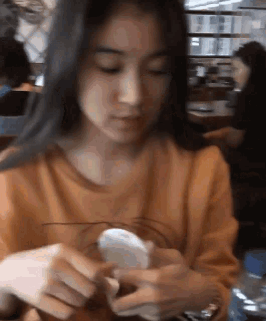 a woman sitting at a table looking at her cell phone