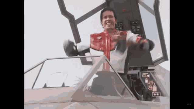 a man is sitting in the cockpit of an airplane .
