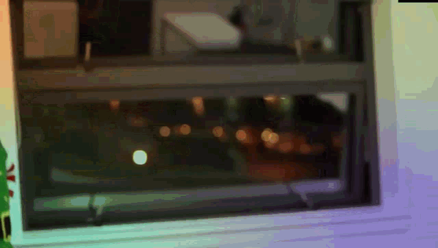 a blurry picture of a window with a christmas tree in the foreground