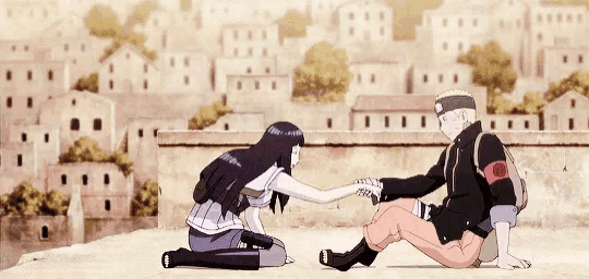 a man and a woman are sitting next to each other and the woman is holding the man 's hand