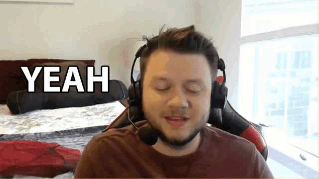 a man wearing headphones and a microphone says " yeah "