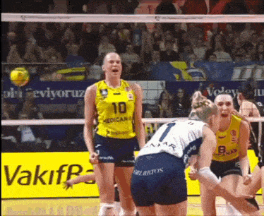 a group of volleyball players are playing a game on a court .