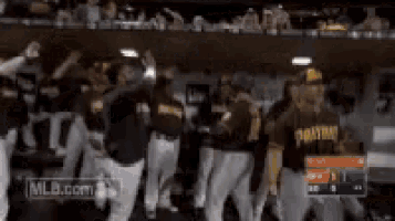 a group of baseball players are standing in a dugout and one of them is wearing a jersey that says pirates .