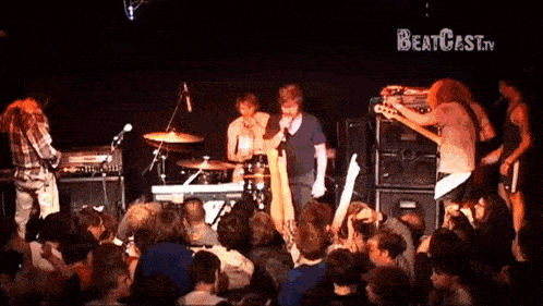 a group of people playing instruments in front of a crowd with the words beatcast.tv on the bottom right