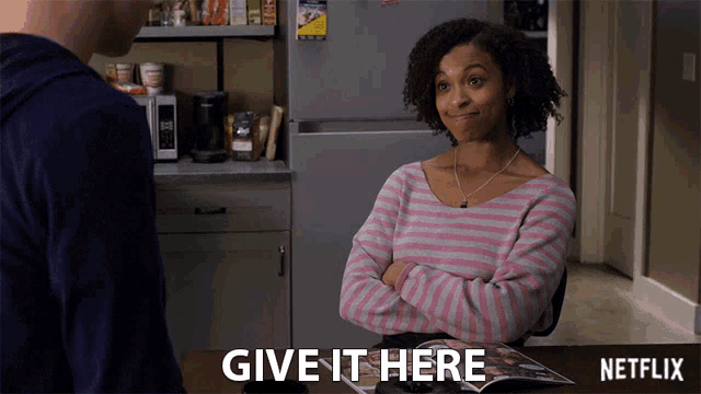 a woman is sitting at a table with a netflix logo on it
