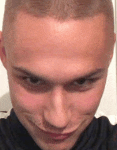 a close up of a man 's face with a shaved head making a funny face .