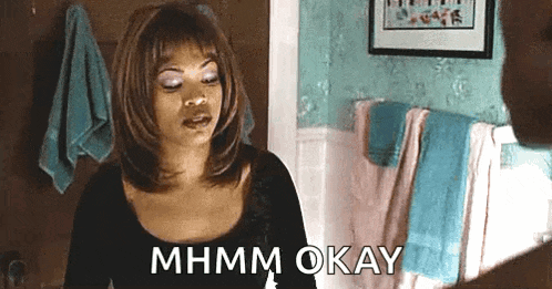 a woman is sitting in a bathroom looking at herself in the mirror and saying mhmm okay .