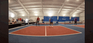 a group of people are playing tennis in a gym