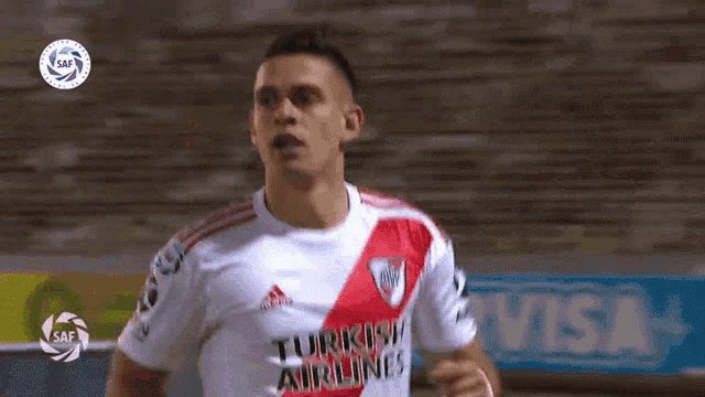 a soccer player wearing a turkish airlines jersey is running