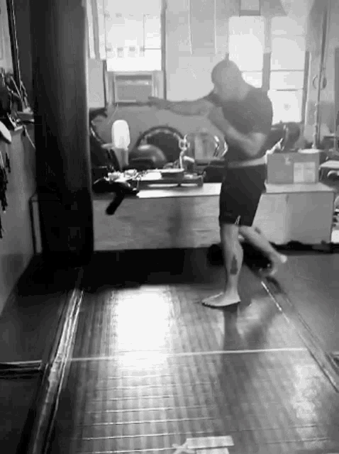 a man with a tattoo on his leg is boxing in a gym