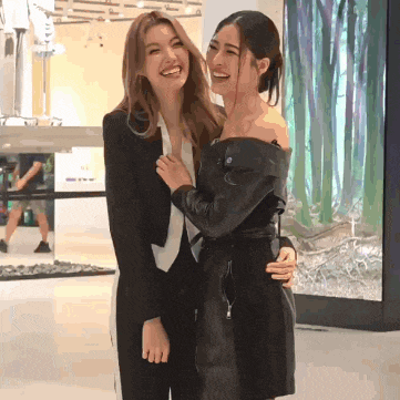 two women are posing for a picture and one of them is wearing a leather jacket