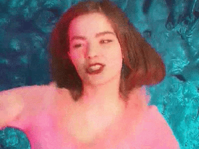 a woman in a pink top is swimming in a pool