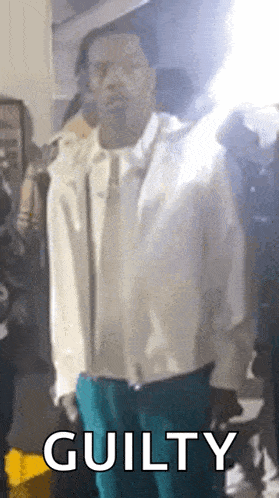 a man in a white jacket and blue pants is standing in front of a crowd with the words guilty written on the bottom