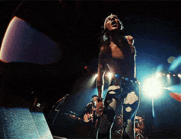 a man singing into a microphone on a stage