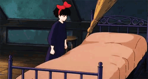 a girl with a red bow on her head is standing in front of a bed