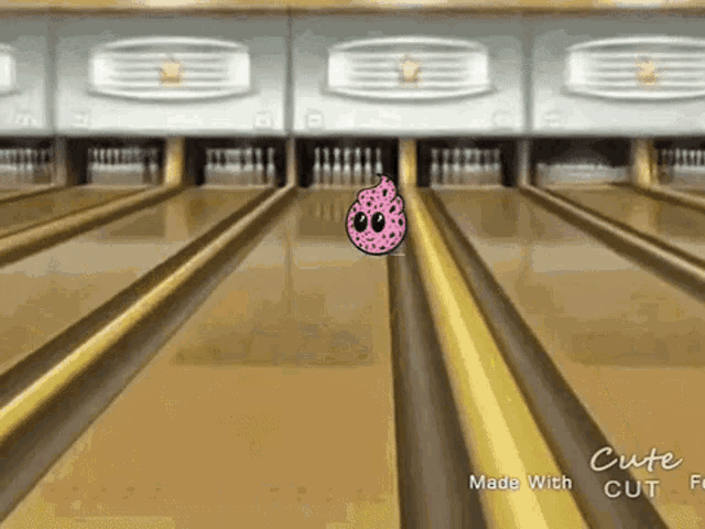 a bowling alley with a bowling ball with a pink face on it