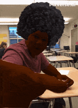 a person with an afro is sitting at a desk with pixverse.ai written on the bottom