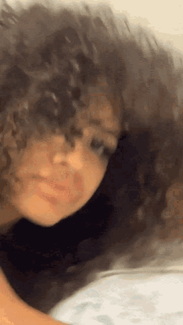 a close up of a woman 's face with her hair blowing in the wind