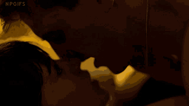 a close up of a man and woman kissing with npgifs written below them