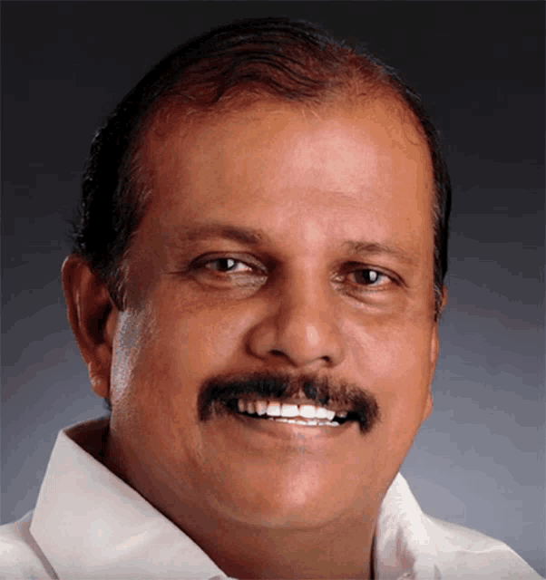 a man with a mustache and white shirt is smiling