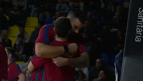two men hugging each other with one wearing a shirt that says ' aguila '