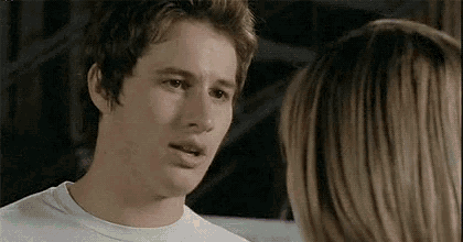a young man in a white shirt is looking at a woman in a white shirt .