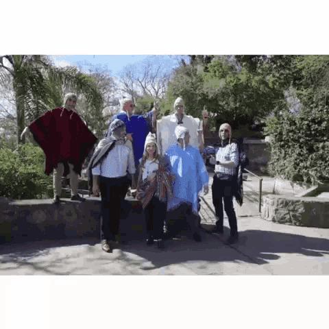 a group of people are posing for a picture while wearing traditional clothing .