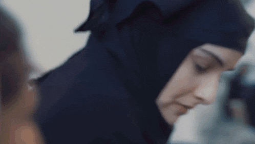 a close up of a woman wearing a hijab looking down