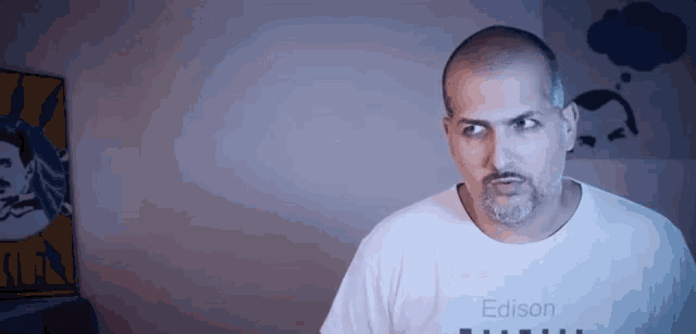 a bald man with a beard is wearing a white edison shirt