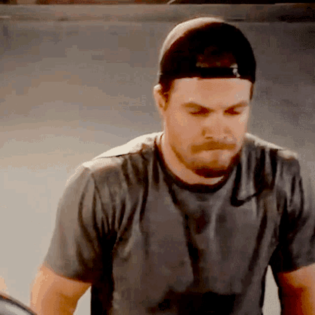 a man wearing a baseball cap and a gray shirt
