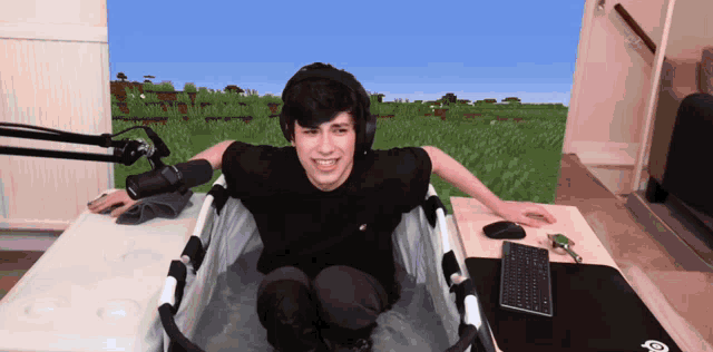 a man is sitting in a bathtub with a keyboard and mouse