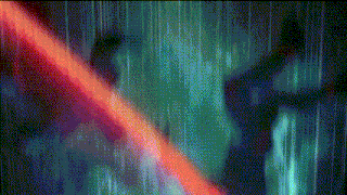 a blurry picture of a person standing in the rain with a red light behind them