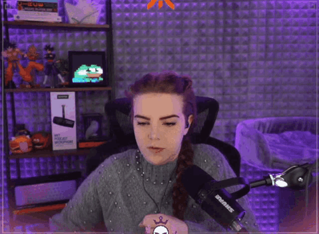 a woman is sitting in front of a microphone that says shure