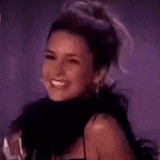 a close up of a woman wearing a black dress and a feather boa .