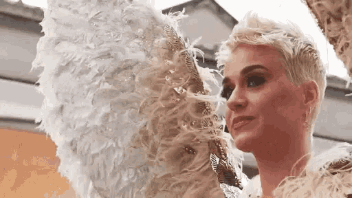 a close up of a woman wearing angel wings and a fan .