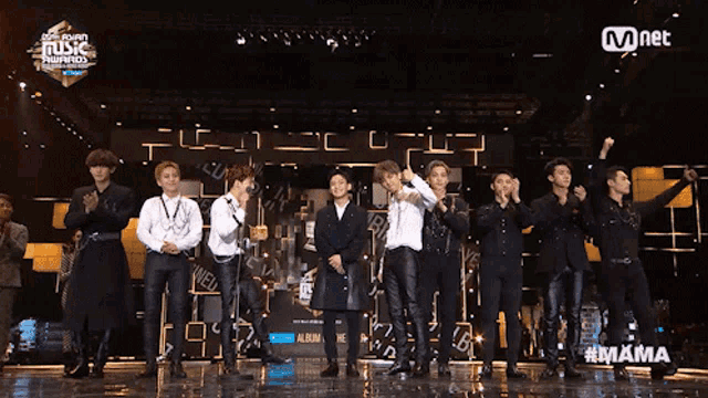 a group of men standing on a stage at a music awards