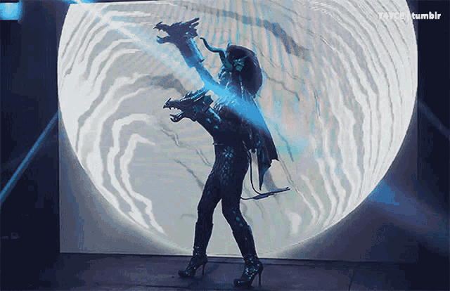 a woman in a dragon costume is standing in front of a screen that says tumblr