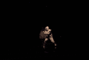 a man in a striped suit is dancing on a stage with blue lights