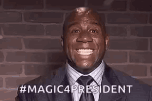 a man in a suit and tie is smiling in front of a brick wall and says `` magic4president '' .