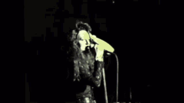 a woman is singing into a microphone on a stage .