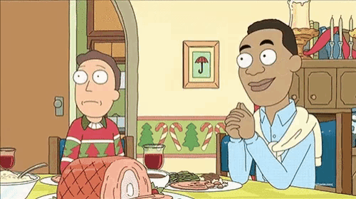 a couple of cartoon characters are sitting at a table with a large ham on it .