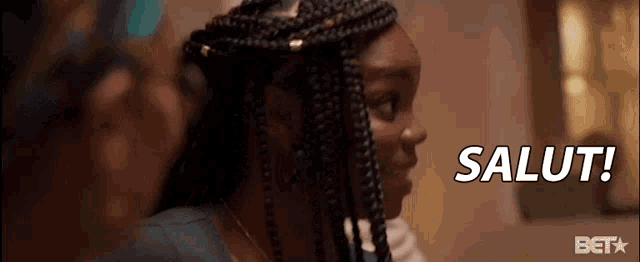 a woman with braids is smiling with the words salut in the background