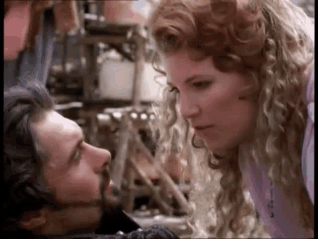 a man and a woman are looking at each other with their eyes closed