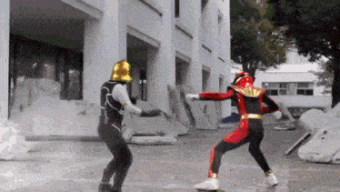 a man in a red and black costume is fighting another man in a black and gold costume