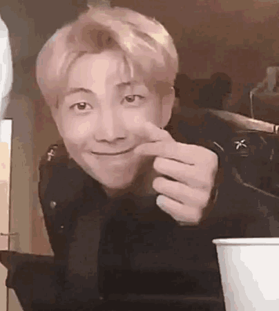 a close up of a person making a funny face with their hand .