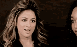 two women are standing next to each other and one has her mouth open and the other has her mouth closed