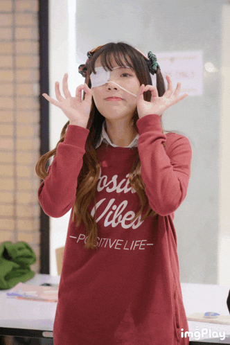 a girl wearing a red sweater that says positive life on it