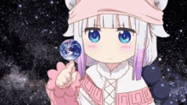 a girl in a pink hat is holding a lollipop in her hand