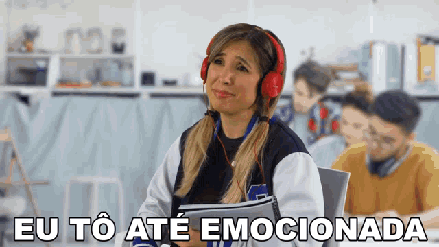 a woman wearing headphones says eu to ate emocionada in a classroom